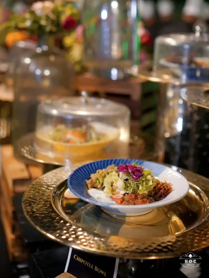 A close-up of our Chipotle Bowl, displayed on a hammered gold platter as part of a larger buffet. This shows how we integrate individual dishes into a grand, cohesive presentation.