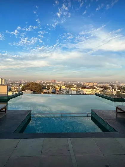 The infinity pool on the rooftop of "The Treehouse" apartments offers stunning panoramic views of the Bengaluru cityscape. This amenity provides residents with a resort-like escape in the heart of the city.