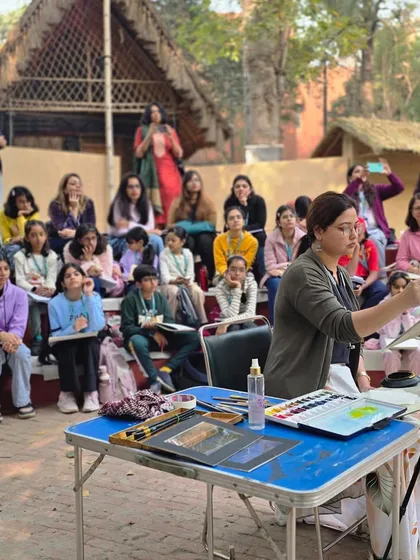 An instructor demonstrates watercolor techniques to a seated audience of students during our workshop at the Craft Museum.
