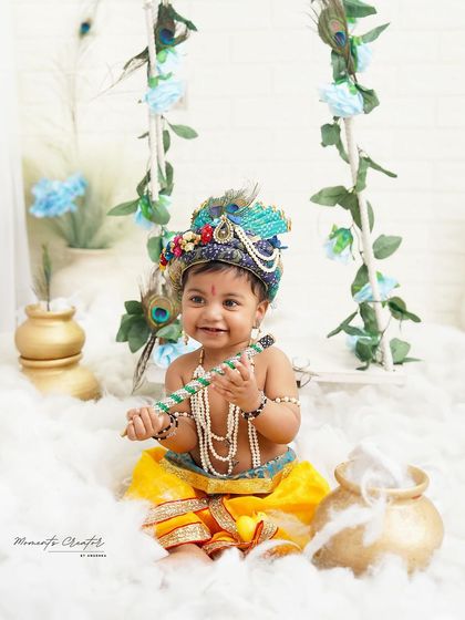 A happy little Krishna sitting amongst the clouds. His bright smile and playful pose with his flute make this a heartwarming and delightful portrait.