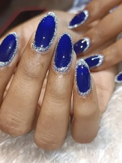 A royal blue manicure with a twist. The deep blue nails are outlined with a fine silver glitter, creating a stunning "frame" effect that is both unique and glamorous.