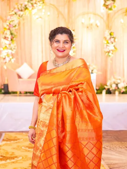 Anchita looking elegant and happy. The makeup complements her beautiful orange silk saree perfectly.