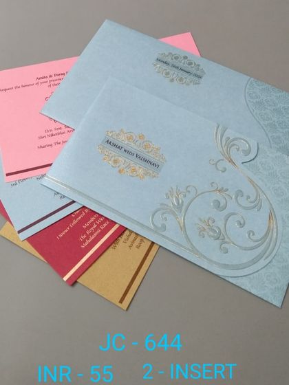 A beautiful light blue invitation with a silver foil scroll design. This affordable card comes with colorful inserts in pink, red, and yellow.