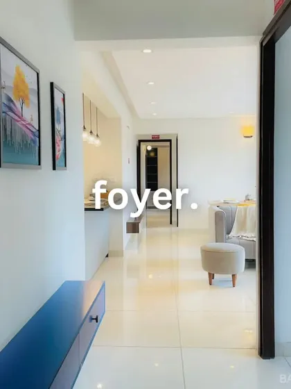 A bright and welcoming foyer design. The slim blue console table adds a pop of color without cluttering the entryway.