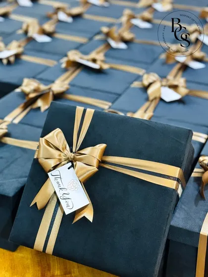 A close-up of our premium corporate gift boxes. These deep green velvet boxes are finished with a custom-branded "Thank You" tag and a striking gold ribbon, designed to leave a lasting impression on valued clients.