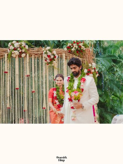 A serene portrait of the couple during their wedding ceremony, framed by traditional floral decor.