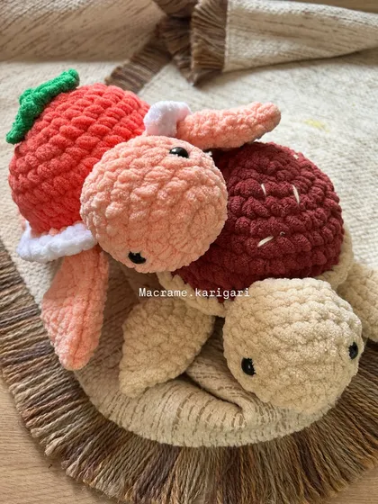 Two of our fruit-themed chunky yarn turtles sitting together. The textures of the chunky yarn make them incredibly soft and perfect for cuddling.