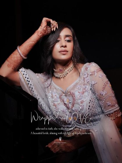 A portrait of the bride titled "Wrapped in Love," showcasing her beautiful lehenga and serene expression.
