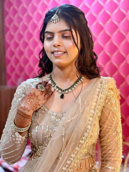 This bride is ready for her engagement. Her hair is styled in a half-updo with soft curls, a popular and versatile choice for pre-wedding events.