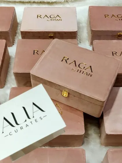 Displaying the "Alia Curates" card alongside the custom-designed Titan Raga watch box. This project involved creating packaging that was both a beautiful product holder and a key piece of influencer marketing collateral.