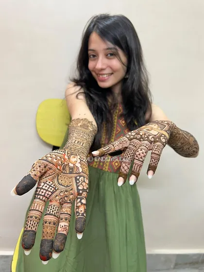 A great view of the palm details, including a bride figure and auspicious symbols, all part of her unique bridal design.