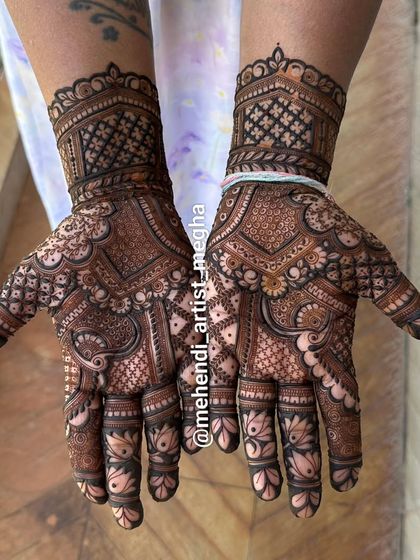 A dense and detailed design where lotus motifs on the fingers complement the intricate patterns covering the palms and wrists.