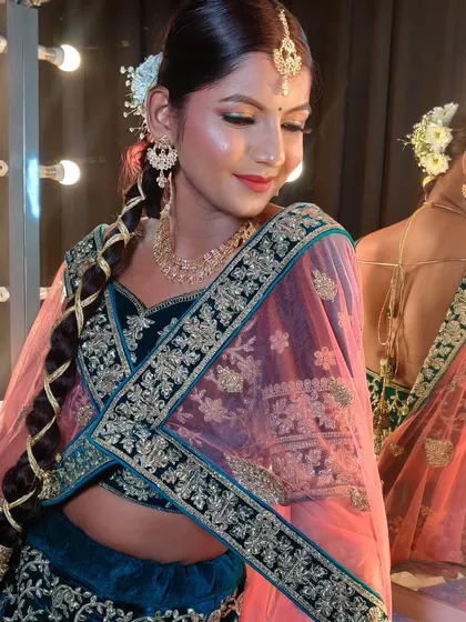 A behind the scenes shot showing the final look in the studio lighting. The highlighter catches the light beautifully, giving her that perfect bridal glow.
