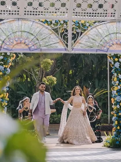 The couple's grand entrance into their Haldi celebration through a beautifully decorated archway. The entire setup was designed to create memorable moments like this one.
