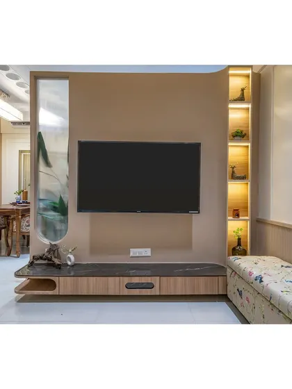 This TV unit features a unique design with a curved partition and an upholstered bench for extra seating, making it a multi-functional and stylish piece.