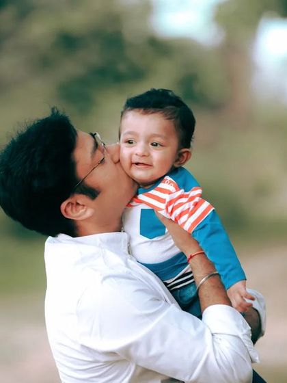 A father's gentle kiss on his son's cheek. This close-up shot from an outdoor session is full of warmth and affection.