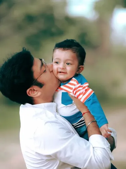 A father's gentle kiss for his son during their family portrait session, a small gesture that tells a big story.