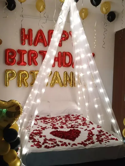 A close-up of the bed canopy with fairy lights and rose petals.