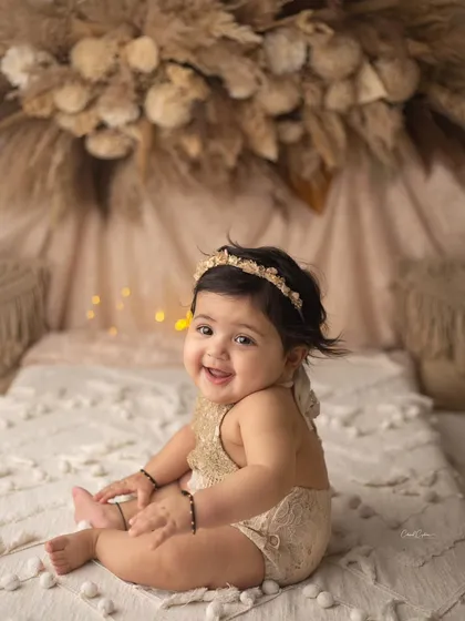 The level of cuteness is just too hard to handle. Her bright eyes and chubby cheeks are a winning combination in this adorable sitter portrait.