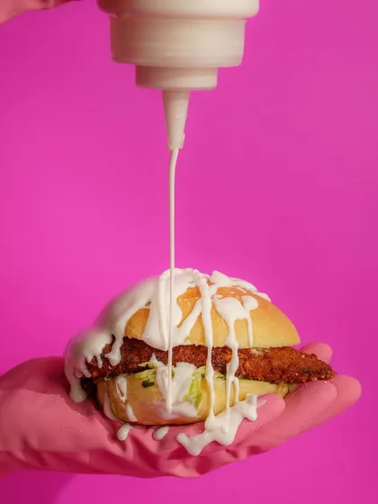 This shot for Dirty Burger is all about fun and breaking the rules. The vibrant pink background and dramatic sauce drizzle create a playful, high-energy image that perfectly matches the brand's edgy persona.