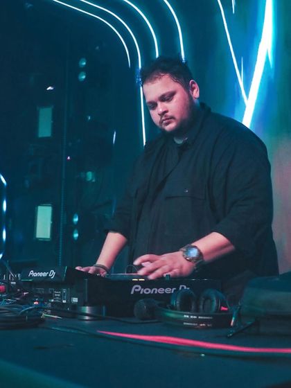 In the spotlight with the neon lights creating a cool, futuristic vibe. This is me in my element, controlling the sound.