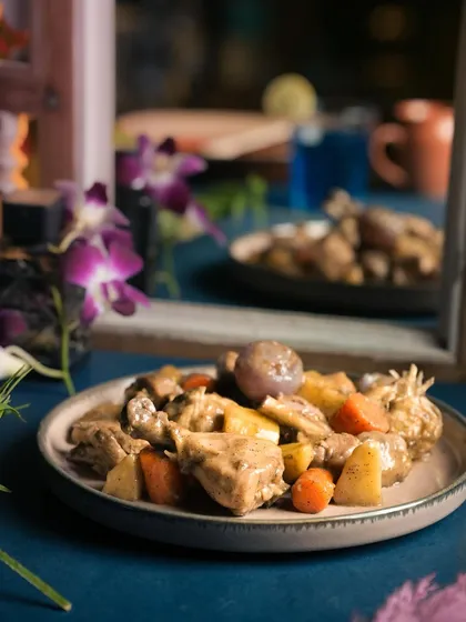 My Dumphukt Rosh Chicken, a slow-cooked dish where chicken is cooked in its own juices with root vegetables like carrots and onions, resulting in incredibly tender meat and a subtle, flavorful gravy.