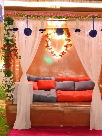 This cozy seating area is decorated with flowers and soft cushions, making it a romantic spot for two. The sheer curtains add a touch of elegance and privacy.