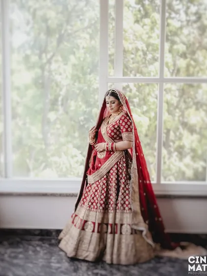 A stunning bridal portrait by a large window, using natural light to create a soft, ethereal glow around her.