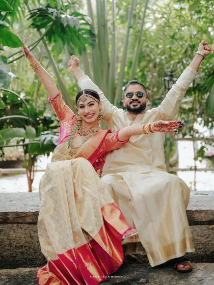 A fun and celebratory portrait of the couple, their arms raised in joy after their wedding ceremony.