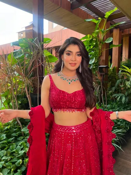 The bride is ready to celebrate in this stunning red ensemble, perfect for making a grand entrance.