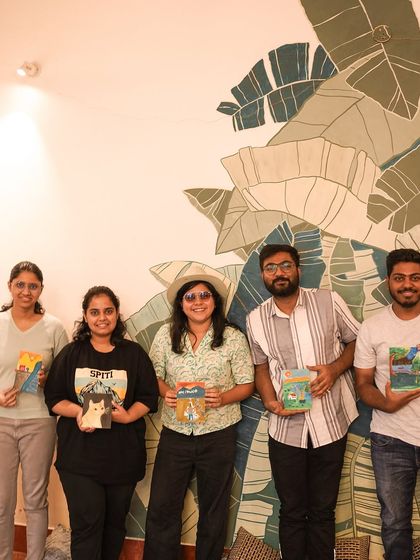 A group of participants proudly holding their finished paintings from our kitten art event.