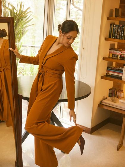 A playful pose with a mirror, showing off the wide-leg trousers and the overall flow of the outfit.