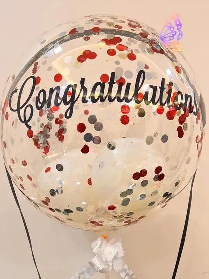 A close-up on the 'Congratulations' balloon, showing the fun confetti mix and the little butterfly detail we added for an extra touch of whimsy.
