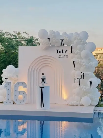 A 'White Paradise' theme for a sweet 16th birthday by the pool. The all-white decor with black ribbon accents creates a minimal, aesthetic, and highly sophisticated look.