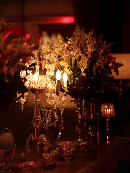 The warm glow of crystal table lamps and chandeliers at an evening event. Lighting is a key ingredient in setting the mood, and here it creates a soft, romantic, and luxurious feel.