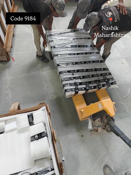 Our team uses a pallet jack to move a heavy, packed granite waterfall within our facility. We have the right equipment to handle these massive pieces safely.