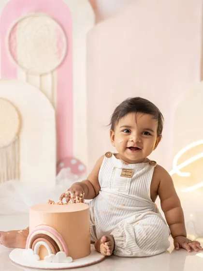 A duplicate of the happy baby boy with his rainbow cake.
