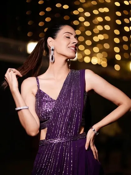 A client having fun in a shimmering purple draped saree. The joy and confidence she exudes is what we strive for with every piece we curate.