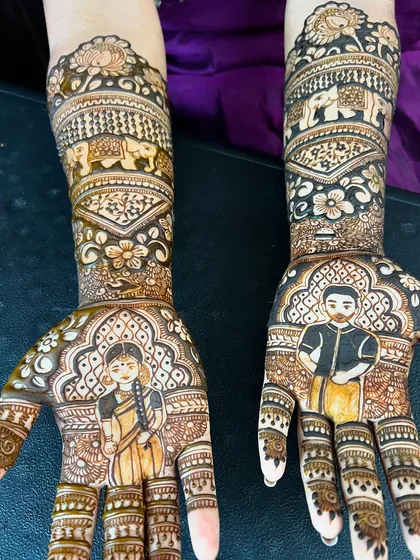 A detailed portrait mehendi for a bride, featuring her and her groom. The design is complemented by traditional elephant motifs and floral patterns.