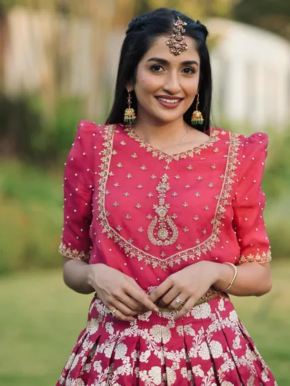 A close-up of the rose pink blouse, featuring exquisite embroidery around the neckline.