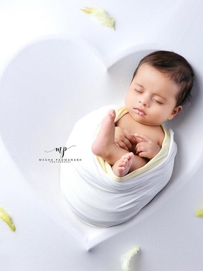 A simple, clean portrait of the baby in the heart prop, without the teddy bear.