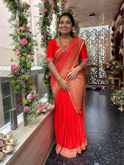 A lovely client in a red bandhani-style saree, paired with a simple, elegant red blouse. This is a perfect look for a pre-wedding pooja or festive gathering.