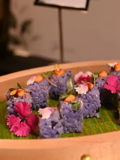 Our Blue Pea Flower Sushi, naturally colored and filled with avocado and cream cheese, is a highlight of our live sushi station. The presentation on a wooden sushi boat adds to the authentic experience.