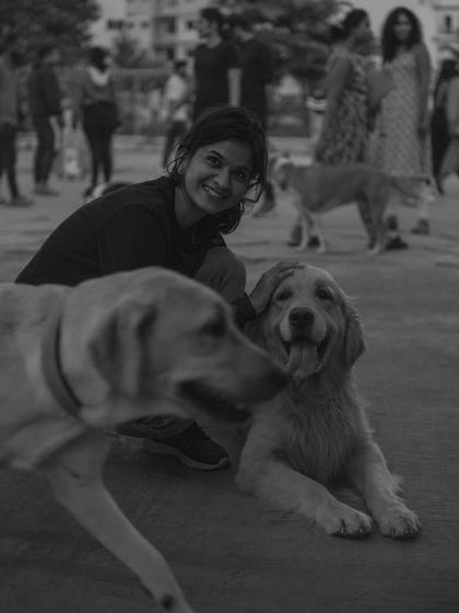 A beautiful black and white photo capturing a moment of pure joy between a visitor and two of our dogs.