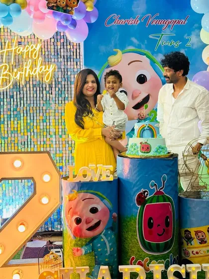 The whole family together, smiling and celebrating their son's second birthday with our colorful Cocomelon setup.