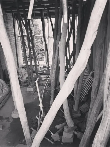 The inside of a project during heavy construction. The dense network of wooden scaffolding supports the structure as it sets.