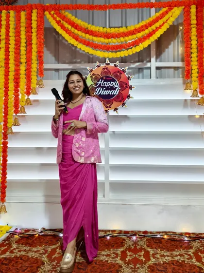 Posing with the mic against the festive Diwali decor at the Vyapar event. The ambiance was perfect for a grand celebration, and I was there to amplify the energy.