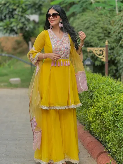 A stunning yellow peplum-style sharara set that I would recommend for a Haldi or Mehendi function. The intricate embroidery and bright color perfectly capture the celebratory mood.