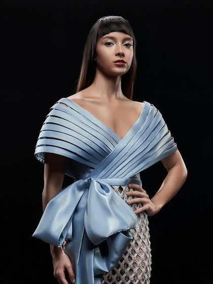 A full-length shot of the Icy Blue Crystal Mesh Dress by Alpana Neeraj, showcasing the statement bow and silhouette.