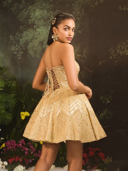 A view of the back of the Jules Dress, highlighting the delicate corset lacing which allows for a perfect fit, and the intricate beadwork across the entire piece.